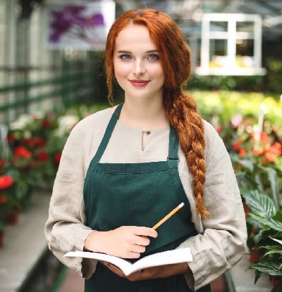 Mujer en un invernadero con delantal verde